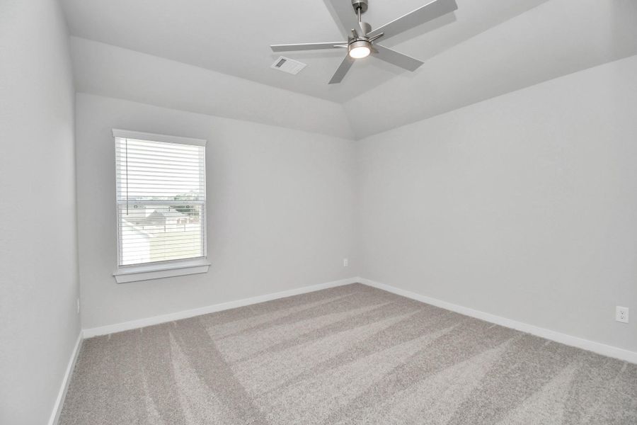 Secondary bedroom features plush carpeting, large windows that let in plenty of natural light, bright paint, and spacious closets. Sample photo of completed home with similar floor plan. Actual colors and selections may vary.