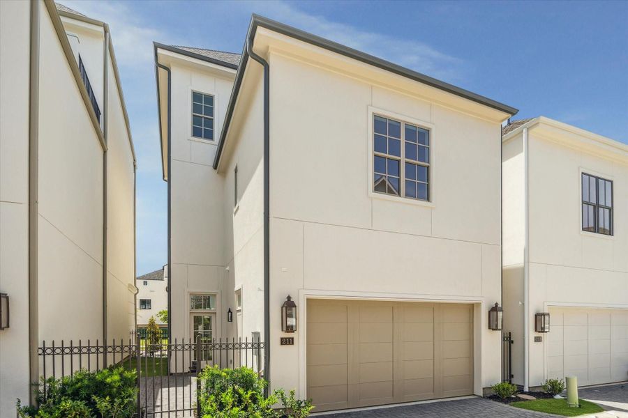 Rear view of 211 Sutton Row, two-car garage, courtyard access and gas lanterns.
