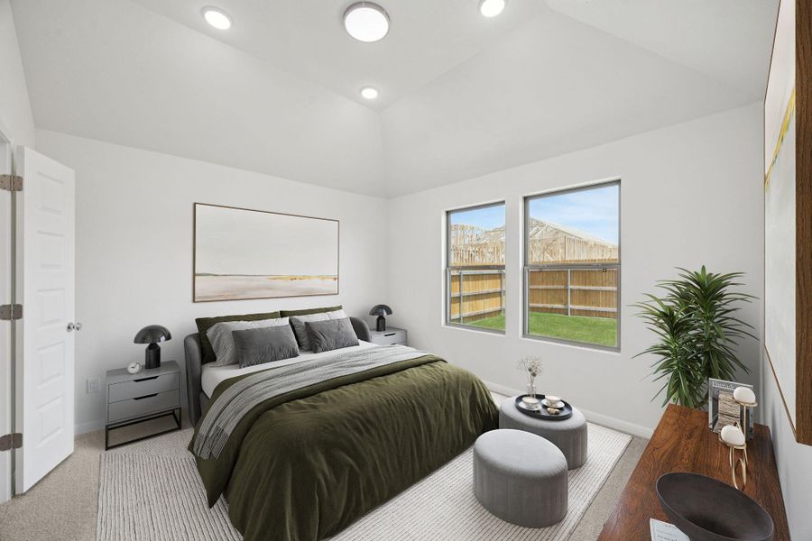 Bedroom with light colored carpet and vaulted ceiling