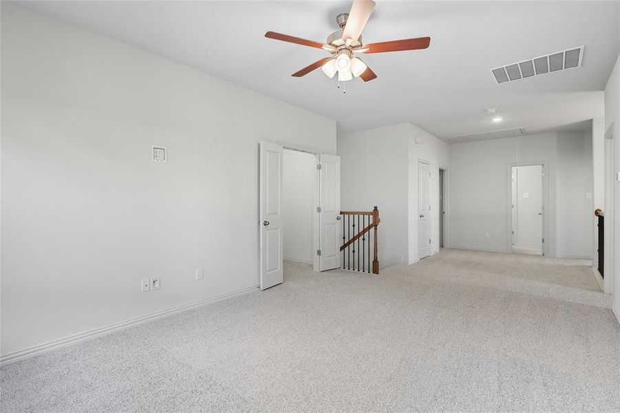 Spare room featuring attic access, carpet flooring, and a ceiling fan Spare room featuring attic access, carpet flooring, and a ceiling fan