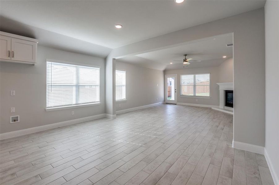 Unfurnished living room with ceiling fan and vaulted ceiling