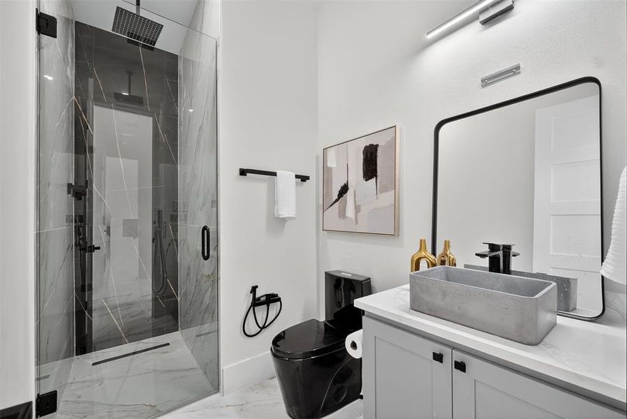 Full bath with vanity, a marble finish shower, and light marble finish flooring