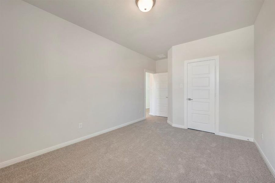 Carpeted empty room featuring baseboards