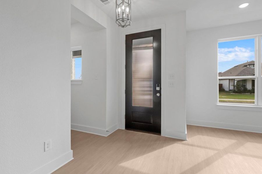 The entryway welcomes you with a beautiful front door and a striking light fixture that set an elegant first impression. The entryway welcomes you with a beautiful front door and a striking light fixture that set an elegant first impression.