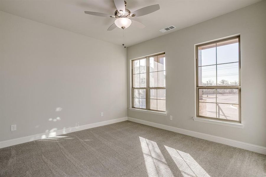 Unfurnished room with ceiling fan and light carpet Unfurnished room with ceiling fan and light carpet