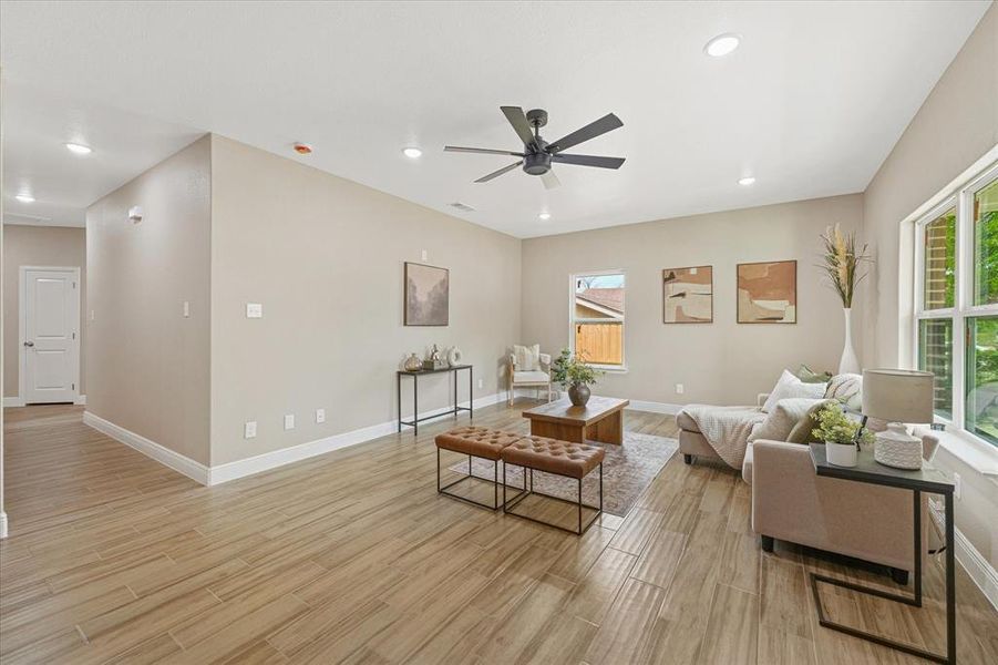 Living room featuring light wood-style flooring, recessed lighting, and ceiling fan Living room featuring light wood-style flooring, recessed lighting, and ceiling fan