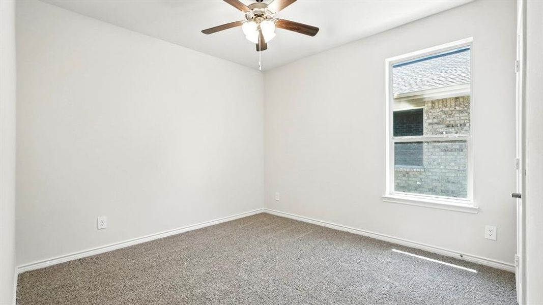 Unfurnished room with dark carpet and a ceiling fan