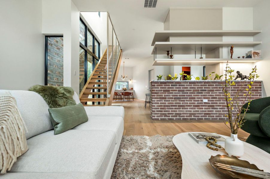 Living area with stairs, visible vents, and wood finished floors Living area with stairs, visible vents, and wood finished floors