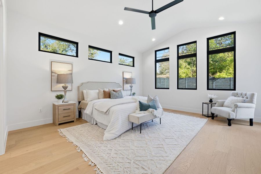 Bedroom featuring vaulted ceiling, light wood-style flooring, multiple windows, a ceiling fan, and recessed lighting