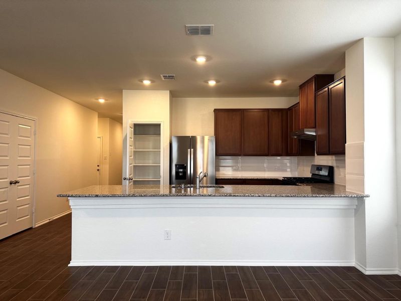 fridge, and black range with gas cooktop