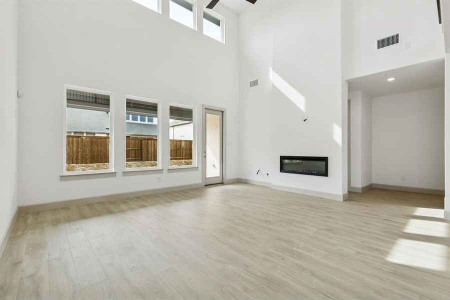 Your spacious new family room is filled with natural light from a wall of dual stacked windows.