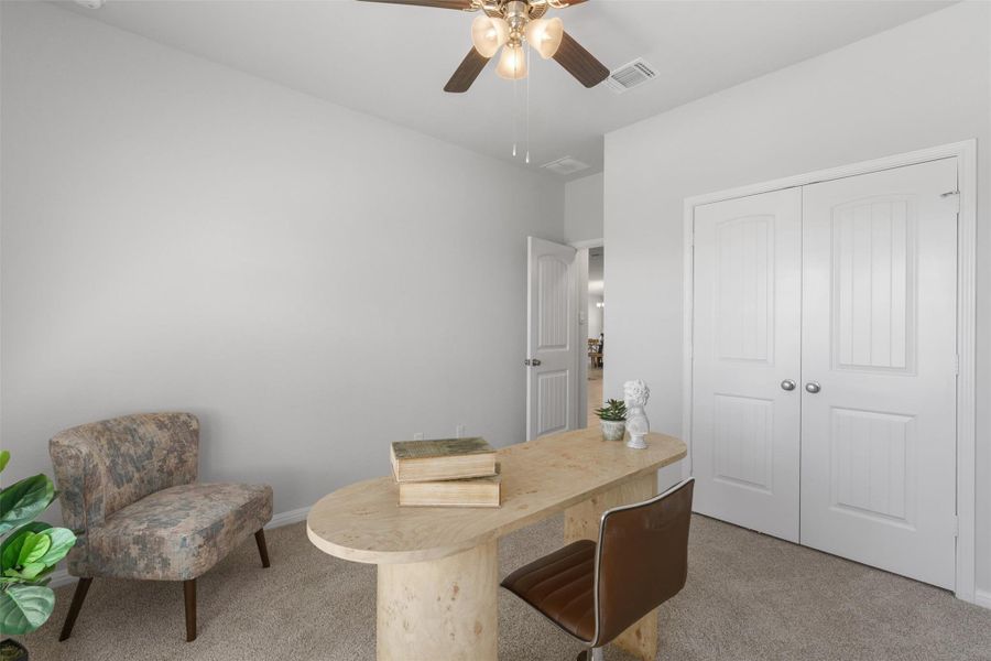 Carpeted office with baseboards and a ceiling fan