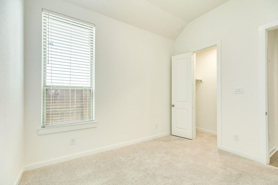 The secondary bedroom also features a view of the side yard and includes a spacious closet.