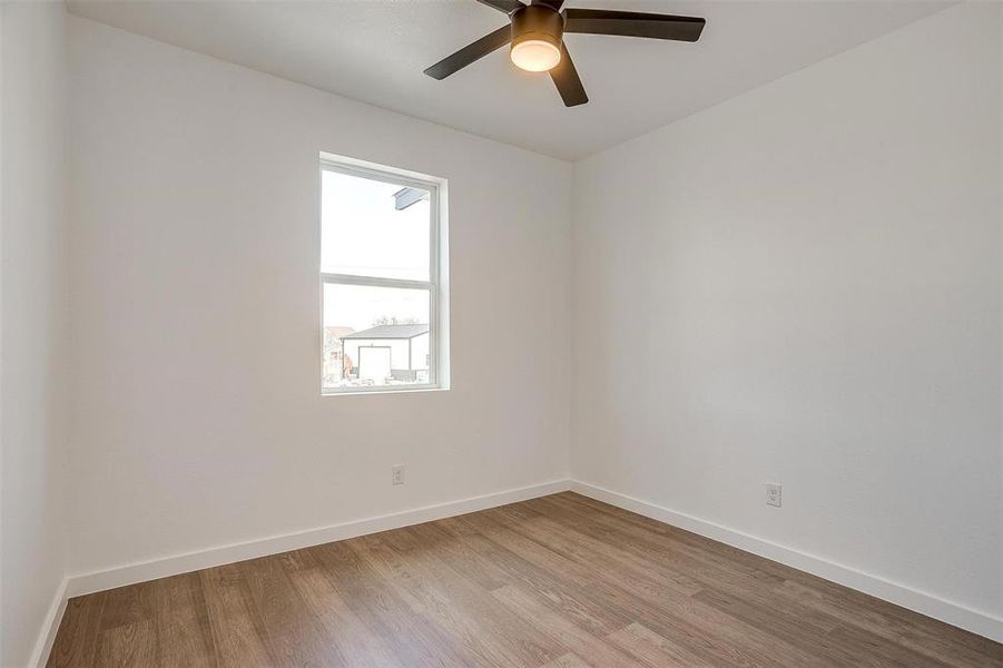Unfurnished room with light wood finished floors, baseboards, and ceiling fan Unfurnished room with light wood finished floors, baseboards, and ceiling fan