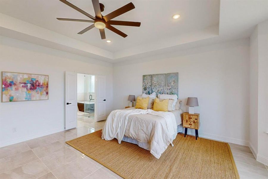 Tiled bedroom with ceiling fan and a raised ceiling