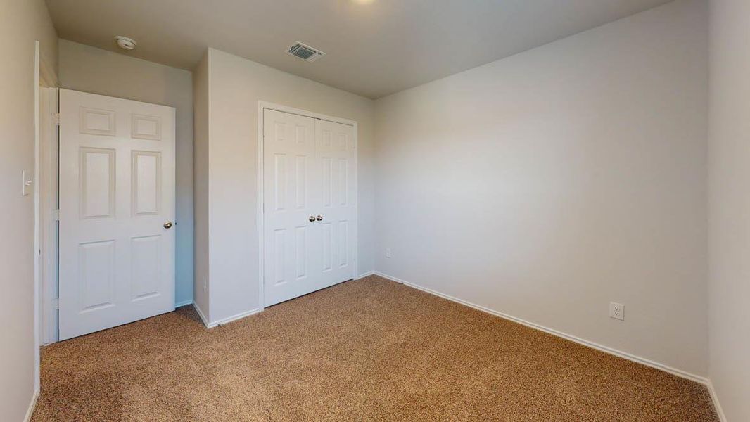 Unfurnished bedroom with carpet and a closet Unfurnished bedroom with carpet and a closet