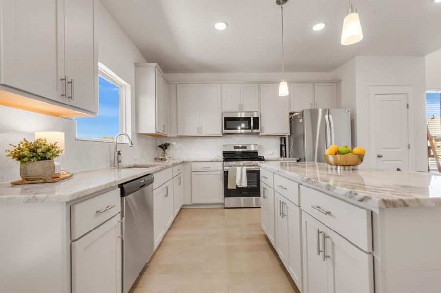 This modern kitchen features sleek white cabinetry, stainless steel appliances, and elegant marble countertops with ample space. Bright and well-lit, it offers both functionality and style, perfect for cooking and entertaining.