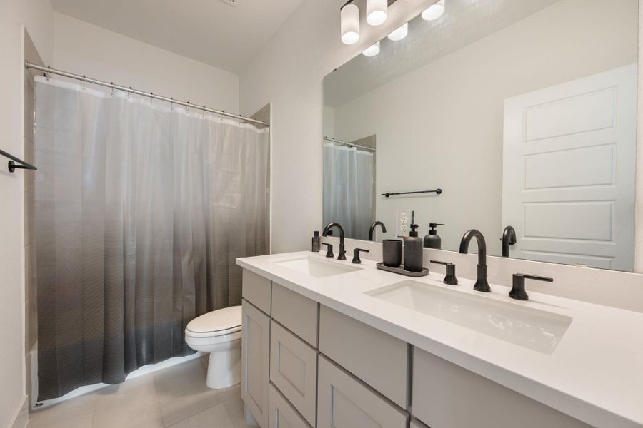 Double vanity with sleek fixtures offers ample counter space for daily routines. Double vanity with sleek fixtures offers ample counter space for daily routines.