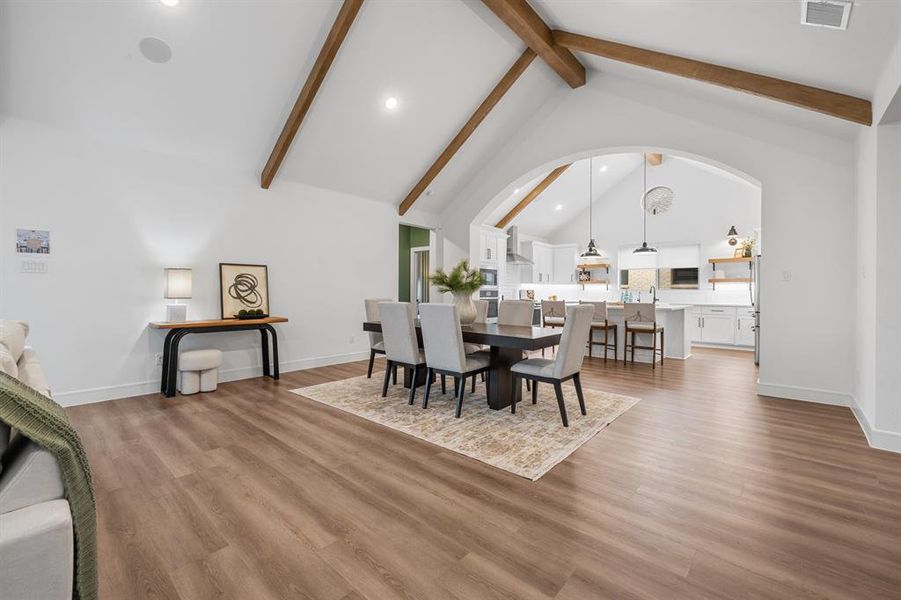 Dining space with high vaulted ceiling, light wood-style flooring, recessed lighting, and beam ceiling