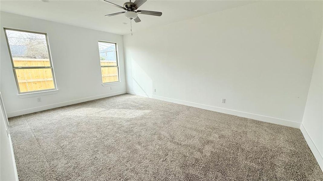 Carpeted empty room with baseboards and ceiling fan