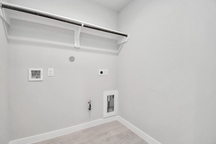 A perfect blend of functionality and comfort. Capture the essence of easy living with a first-floor laundry room, thoughtfully equipped with shelving for effortless organization. Both electric and gas connections available. Sample photo of completed home with similar floor plan. Actual colors and selections may vary. A perfect blend of functionality and comfort. Capture the essence of easy living with a first-floor laundry room, thoughtfully equipped with shelving for effortless organization. Both electric and gas connections available. Sample photo of completed home with similar floor plan. Actual colors and selections may vary.