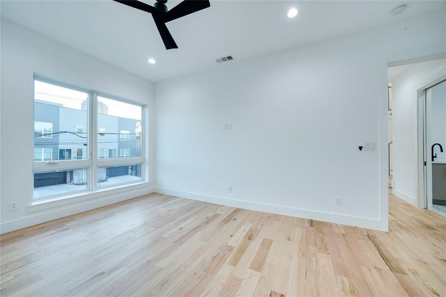 Empty room with light hardwood / wood-style floors and ceiling fan