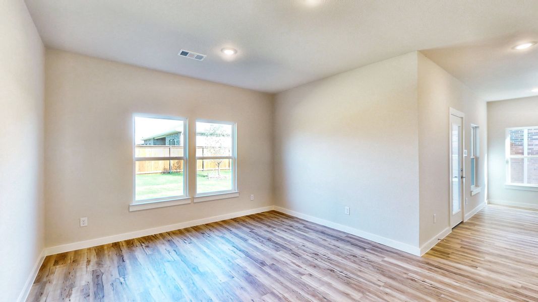 A room with a wood floor and windows.