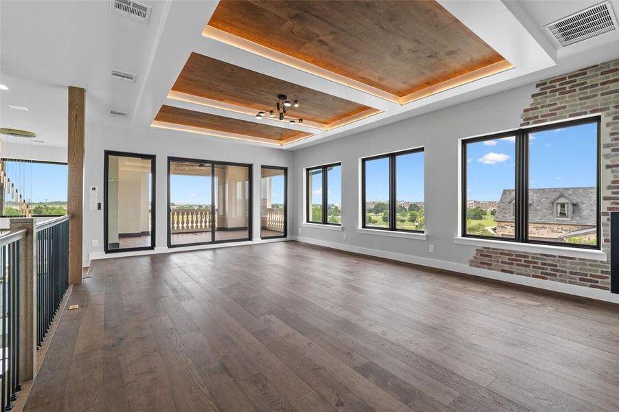 Unfurnished living room featuring wooden ceiling, a raised ceiling, and dark hardwood / wood-style floors