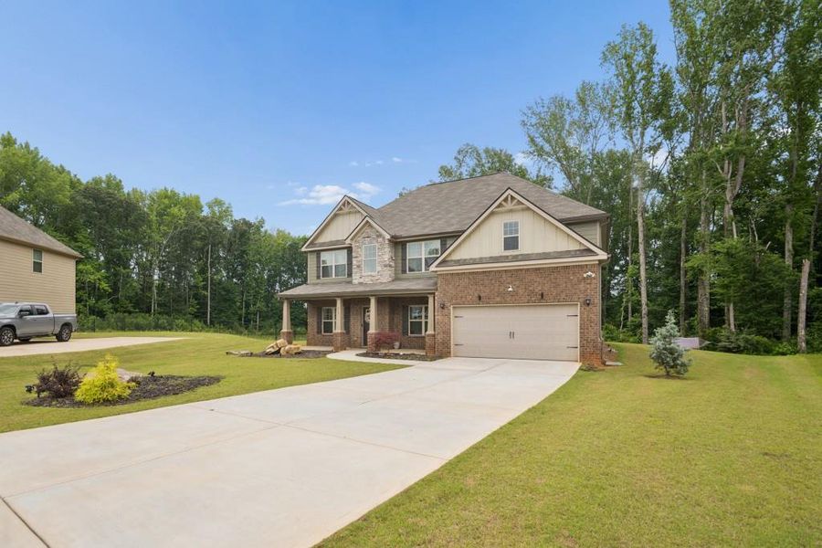 Front exterior of a new home in Nine Oaks, Locust Grove, GA, highlighting curb appeal (Image 23). Front exterior of a new home in Nine Oaks, Locust Grove, GA, highlighting curb appeal (Image 23).