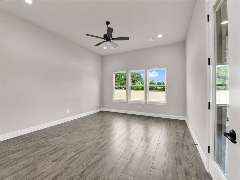 Empty room with recessed lighting, dark wood-style flooring, a ceiling fan, and baseboards Empty room with recessed lighting, dark wood-style flooring, a ceiling fan, and baseboards