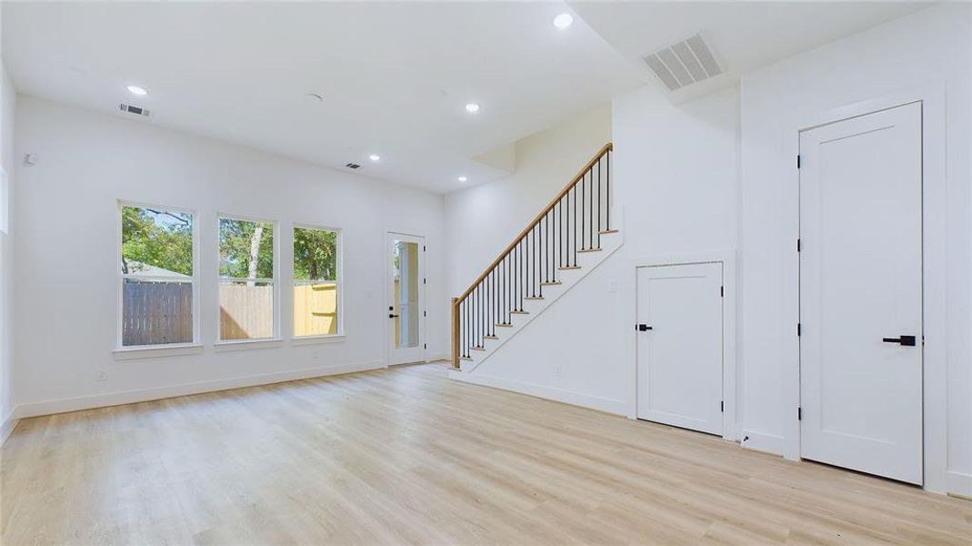 Alternate view of the living space. A cleverly positioned storage closet beneath the staircase maximizes the home's usable space. The door on the left opens to a generous 20x20 yard, offering ample outdoor space.