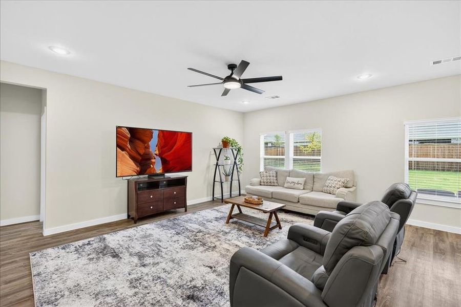 Living room with luxury vinyl flooring, recessed lighting, and a ceiling fan Living room with luxury vinyl flooring, recessed lighting, and a ceiling fan