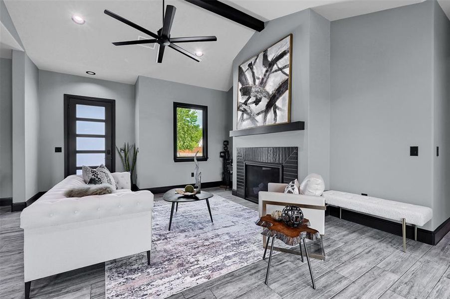 Living room featuring wood finished floors, baseboards, a fireplace, and recessed lighting Living room featuring wood finished floors, baseboards, a fireplace, and recessed lighting