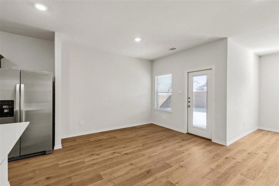 Open-concept living area featuring wood-finish flooring, recessed lighting, and a white interior color palette