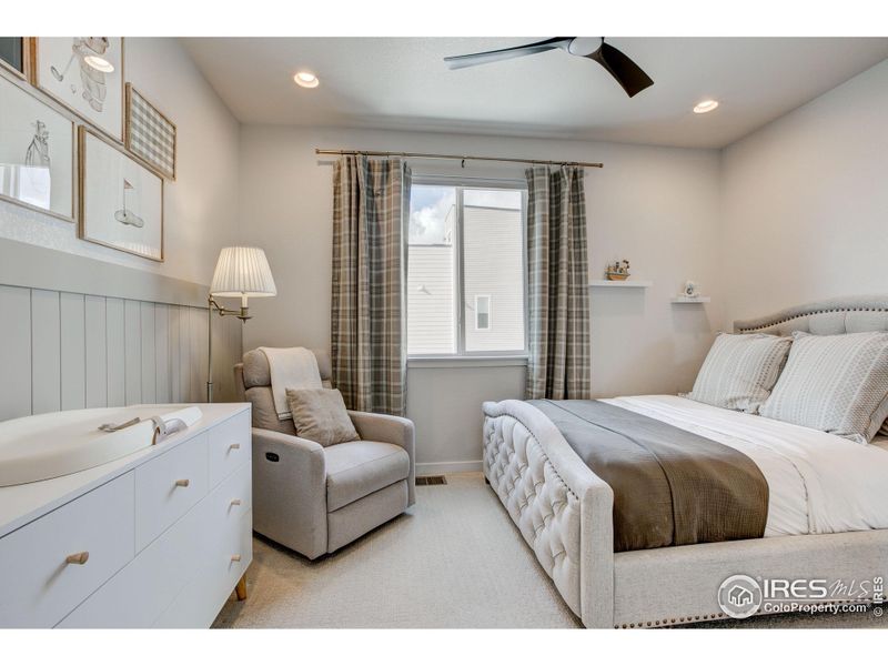 Guest Bedroom with custom wall treatment, large window with mountain views and ceiling fan.