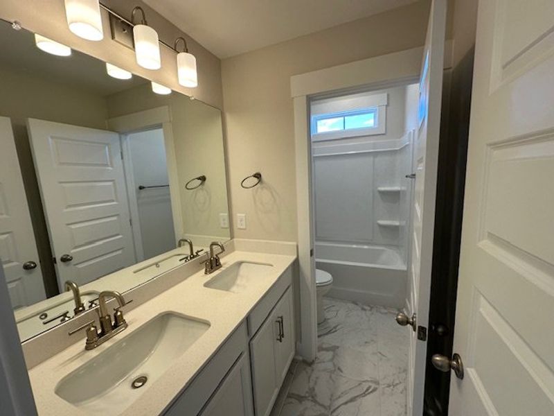 This clean and bright bathroom features a dual van