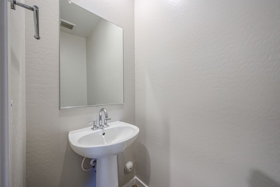 A bathroom with a mirror and sink. A bathroom with a mirror and sink.