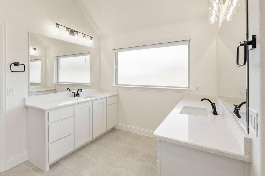 White bathroom with double vanity, soaking tub, black fixtures, and tile floors White bathroom with double vanity, soaking tub, black fixtures, and tile floors