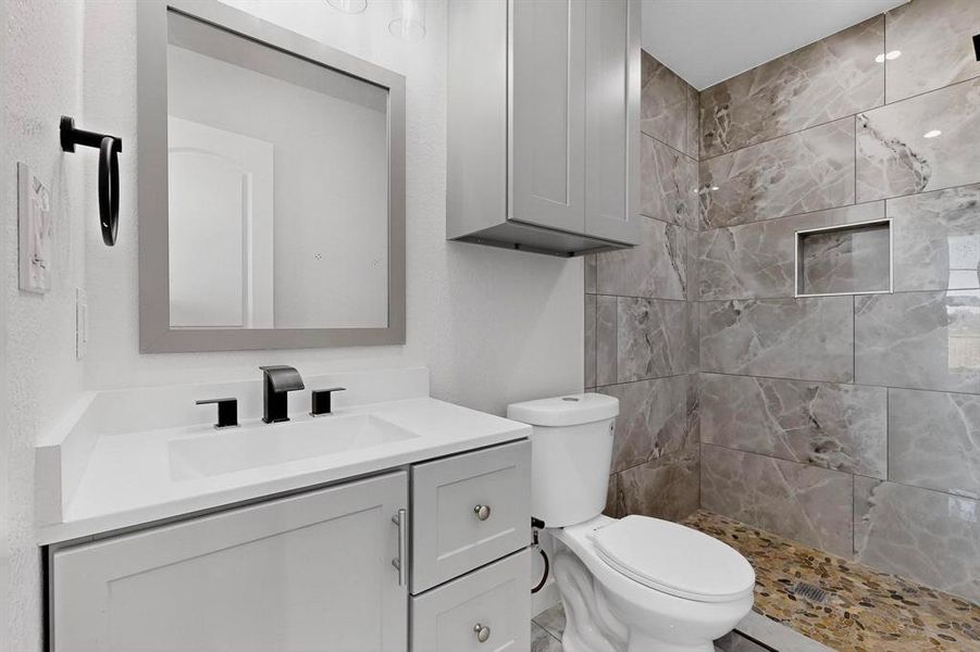 Bathroom featuring vanity and tiled shower