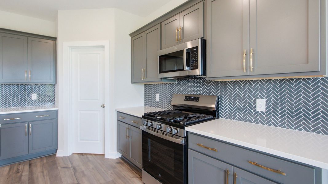 Convenient storage options with pantry door, open countertops, and various cabinet spacing