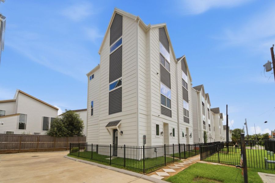 A dynamic side view highlights thehome’s impressive three-storyprofile, modern gabled rooflines,and abundant windows. Freshlandscaping, secure fencing, and aclean private drive complementthe bold exterior design whilecreating a bright, stylish firstimpression.
