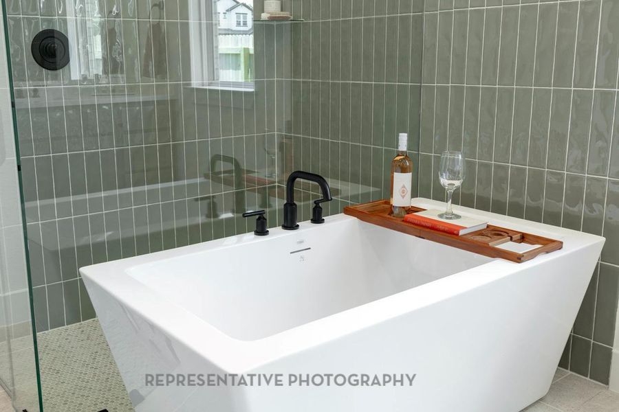 Full bathroom featuring tile walls, a freestanding tub, and tile patterned flooring