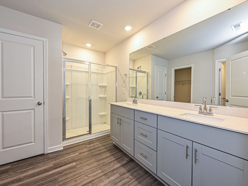 The primary bathroom features a walk-in closet and dual vanities.