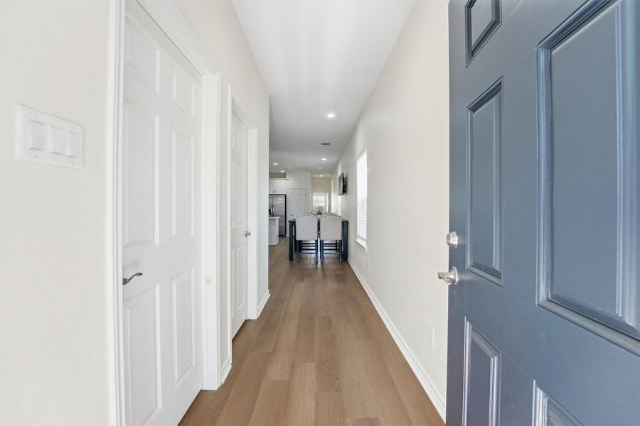 A bright interior hallway welcomes you inside, where durable flooring, recessed lighting, and crisp finishes reflect the home’s modern construction and low-maintenance appeal.