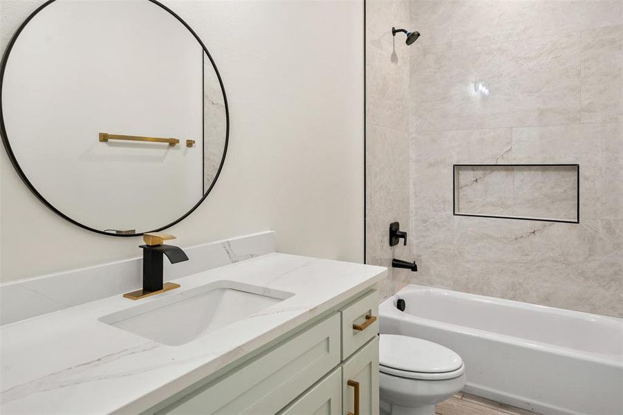 Bathroom featuring a white quartz countertop, integrated rectangular sink, and a black and gold single-handle faucet Bathroom featuring a white quartz countertop, integrated rectangular sink, and a black and gold single-handle faucet