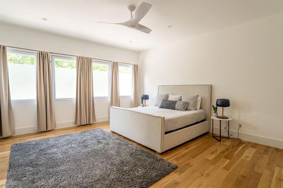 Bedroom with ceiling fan and light wood-type flooring Bedroom with ceiling fan and light wood-type flooring