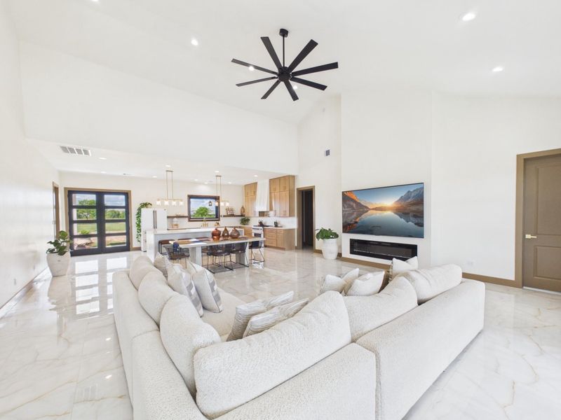 Spacious open concept living area with soaring ceilings and an electric fireplace