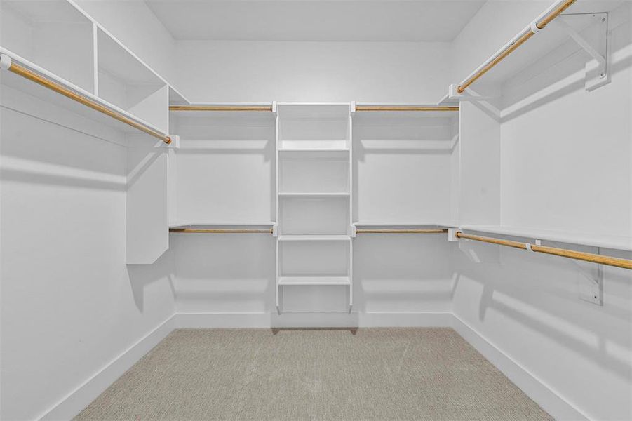 Walk in closet with light colored carpet