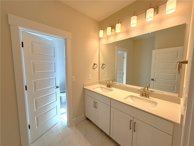 This bathroom features a double vanity and sleek m