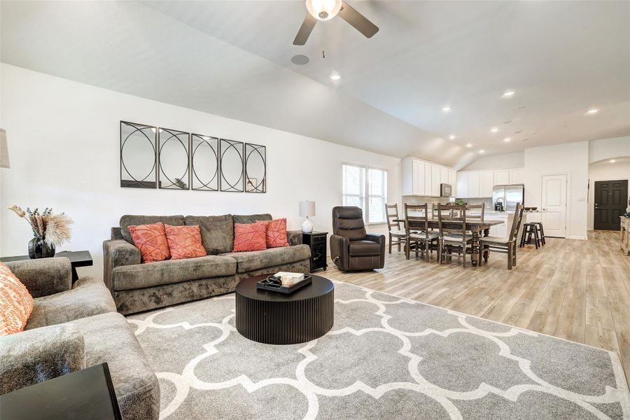 Living area featuring ceiling fan, light luxury vinyl floors, lofted ceiling, and recessed lighting